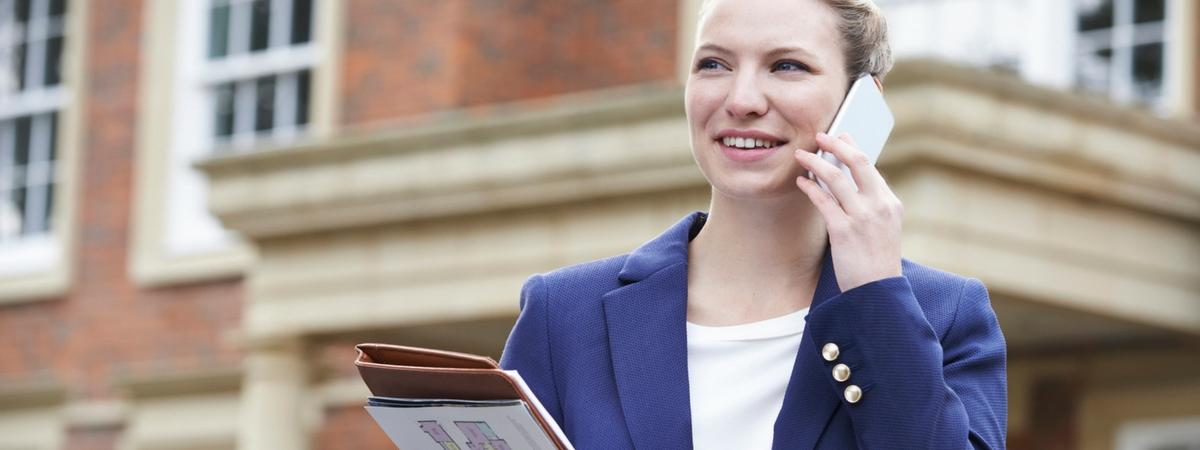 a successful real estate agent talking on the phone with a prospect