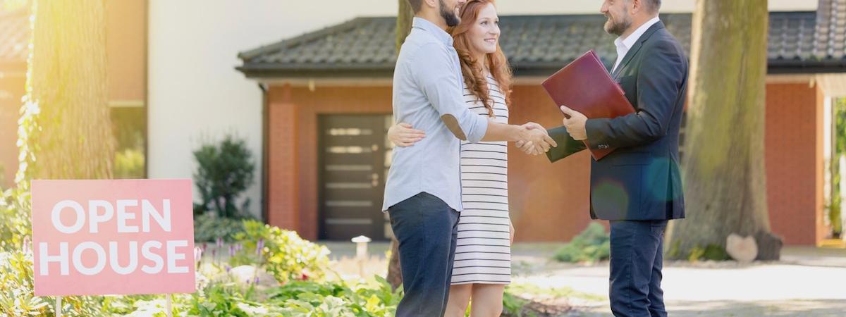 real estate agent greeting visitors during an open house